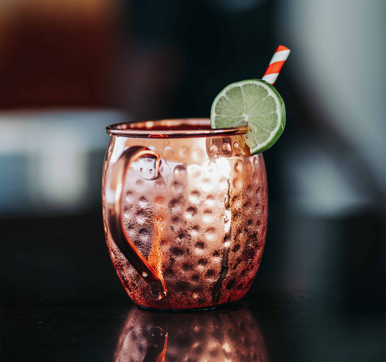 moscow mule en taza de cobre con rodaja de limón y popote