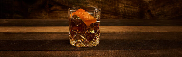 old fashioned clásico con bourbon y twist de naranja en vaso corto